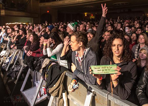 Fan holding sign that says "Decide what to be, and go be it" --Avett Brothers